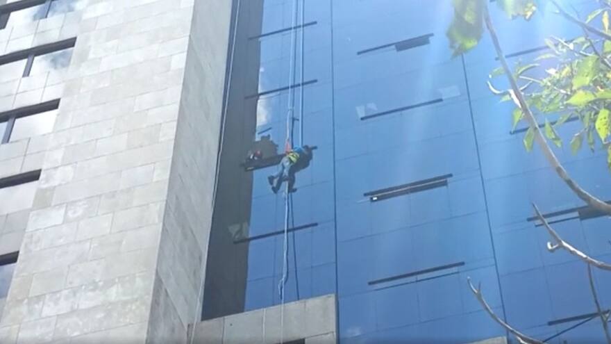 Rescatan a limpiavidrios que quedó colgando de un noveno piso