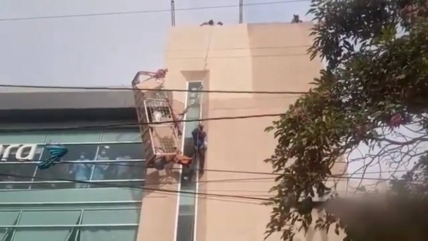 ¡Susto en las alturas! Obreros quedaron colgando tras daño de andamio